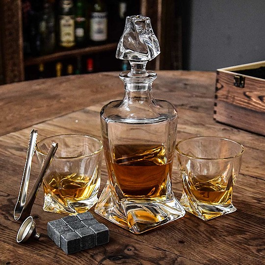 Include un decanter, due bicchieri, nove pietre per il raffreddamento del whisky, un imbuto e delle pinze. 