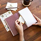 Include 2 pagine di adesivi, un nastro segnalibro e una tasca interna.
